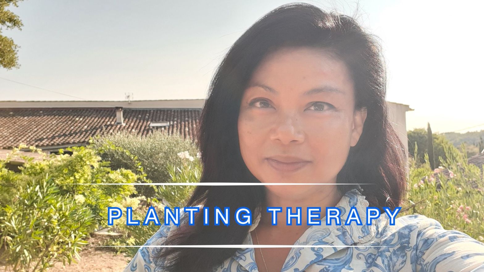 Geneveive Cheung standing in a Tuscan garden in soft morning light, with greenery and tiled rooftops behind her, overlaid with the words “Planting Therapy.”
