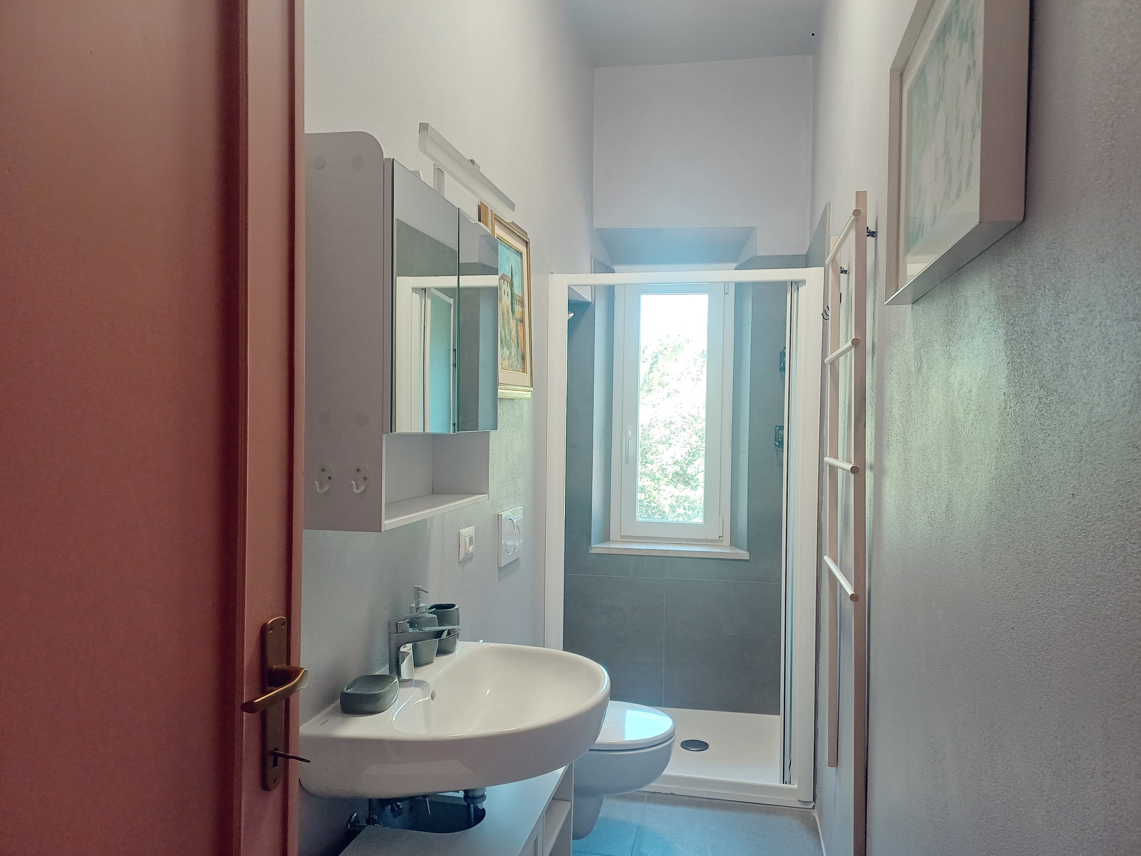 Modern private bathroom with shower, sink, and natural light at Genevieve Grove