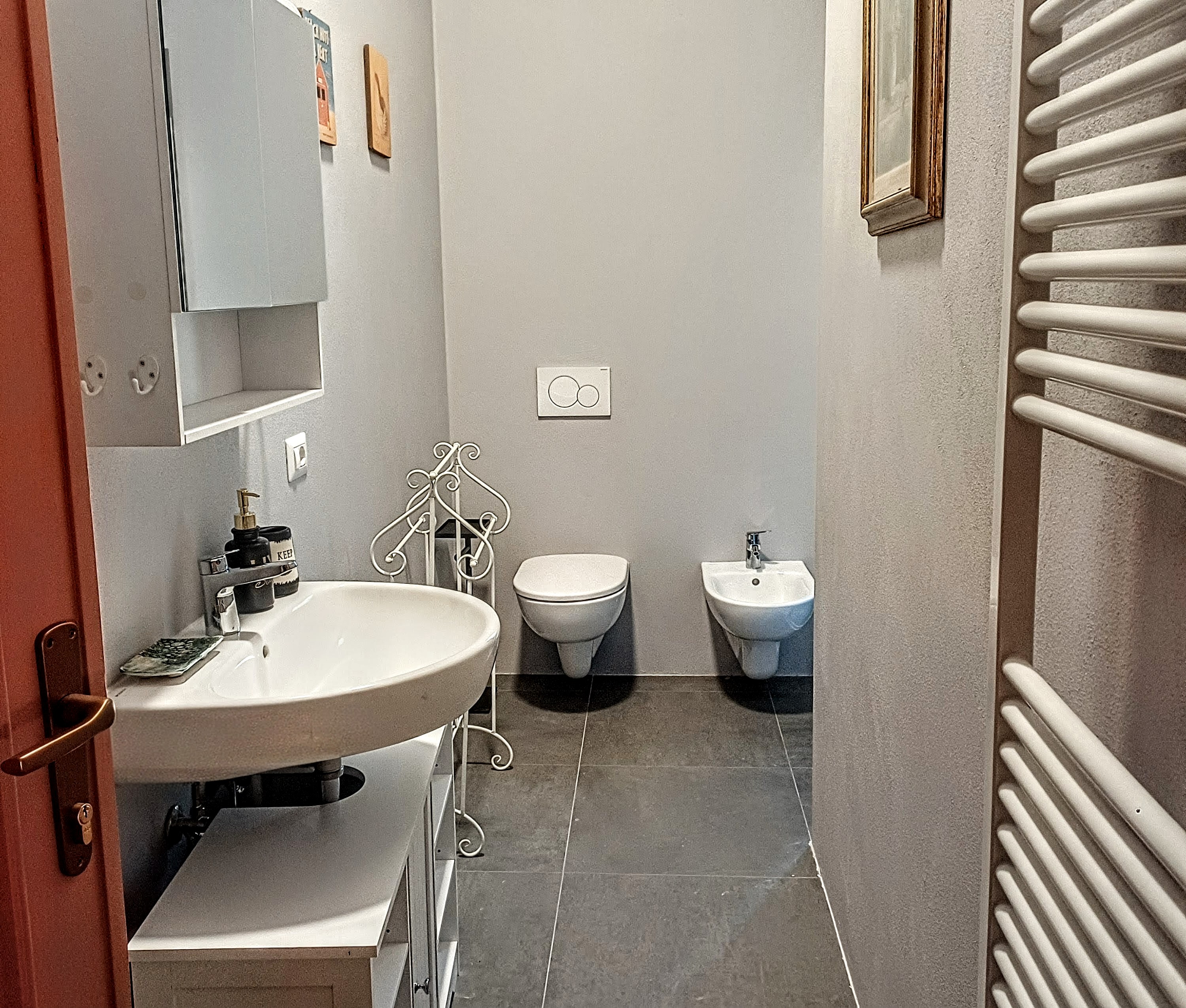 Modern private bathroom with sink, toilet, bidet, and towel warmer in L'Iris Room at Genevieve Grove
