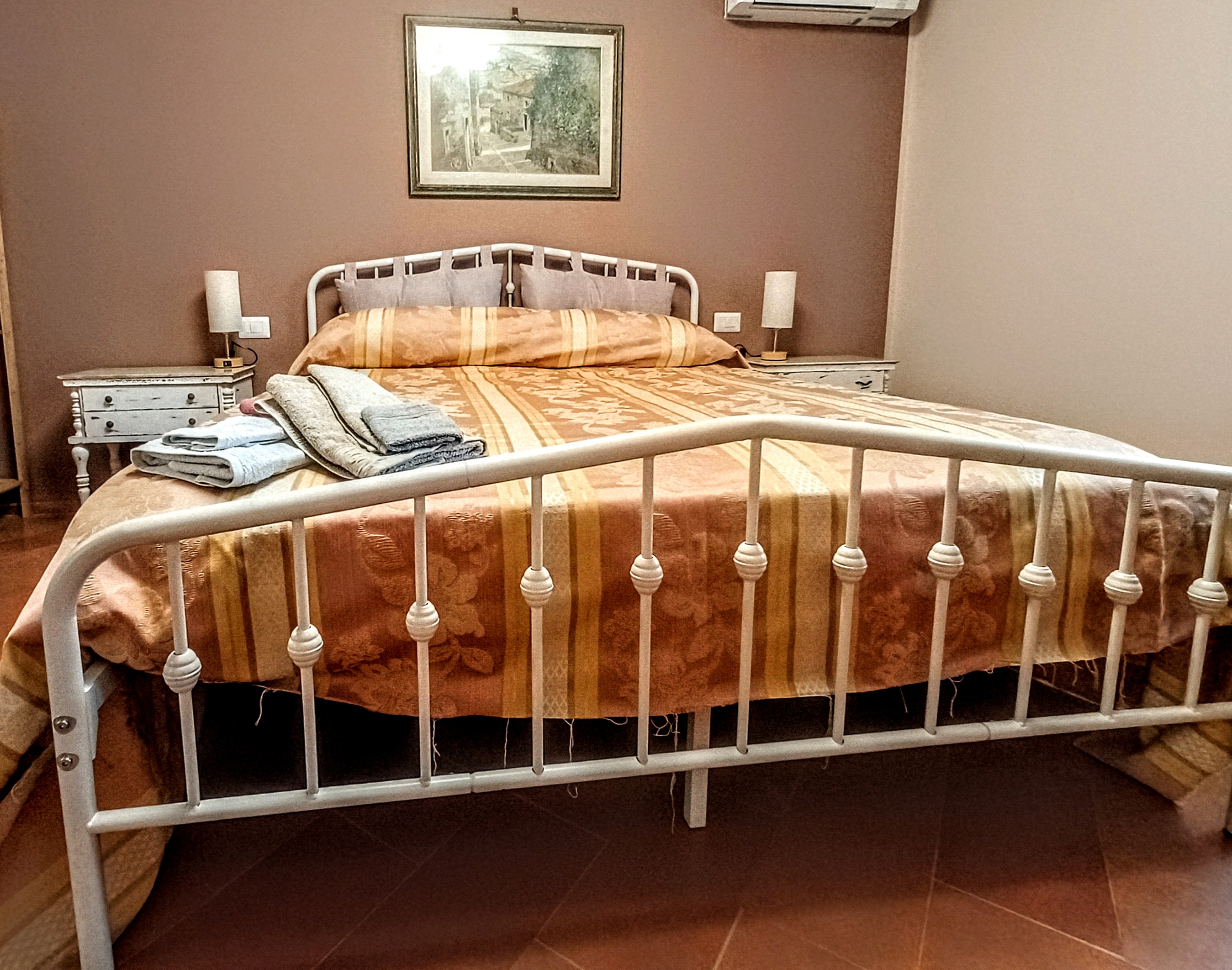 Double bedroom with king-size bed, air conditioning, and traditional furnishings in L'Iris Room at Genevieve Grove, Tuscany