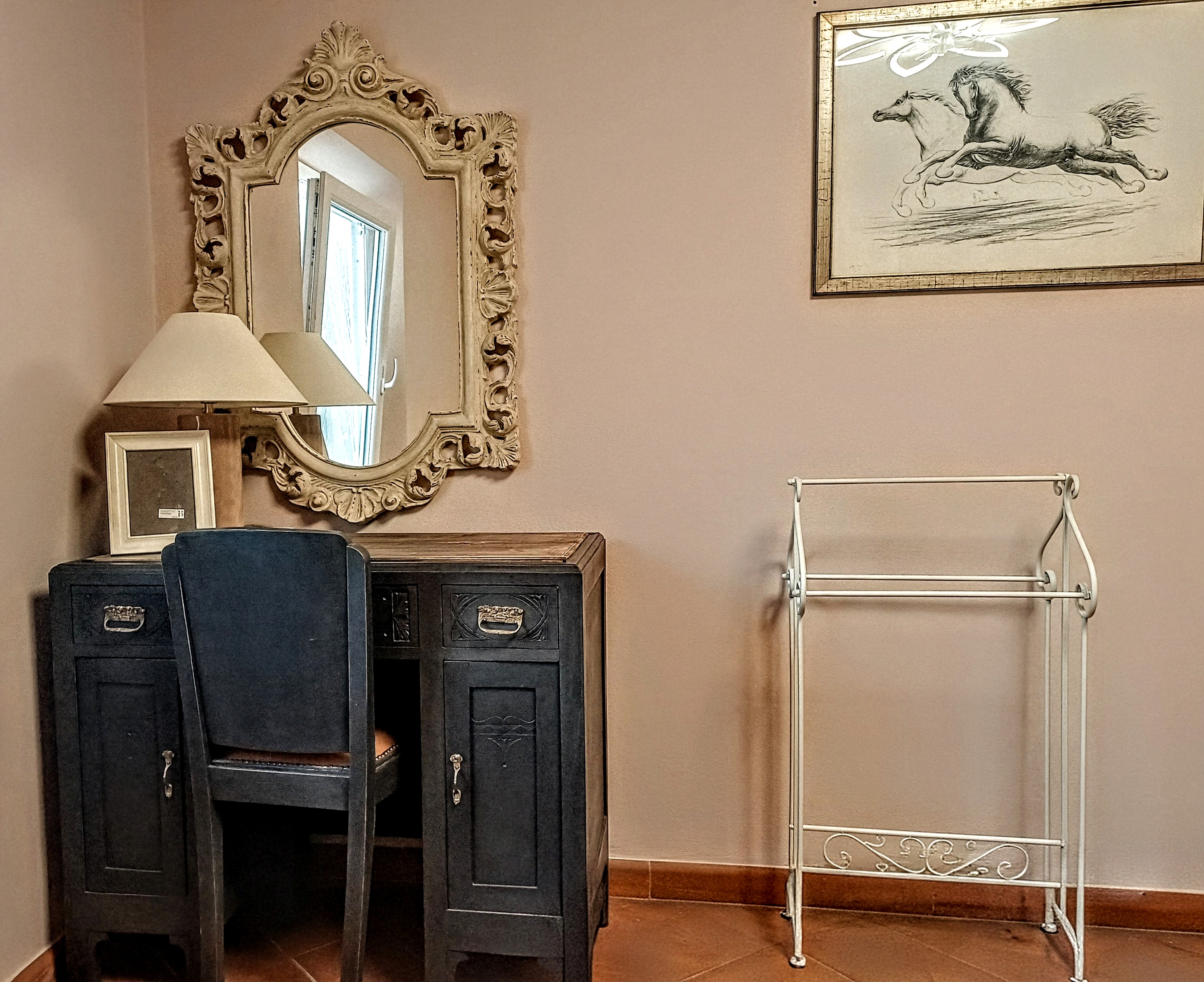 Antique writing desk with decorative mirror and seating area in L'Iris Room at Genevieve Grove, Tuscany