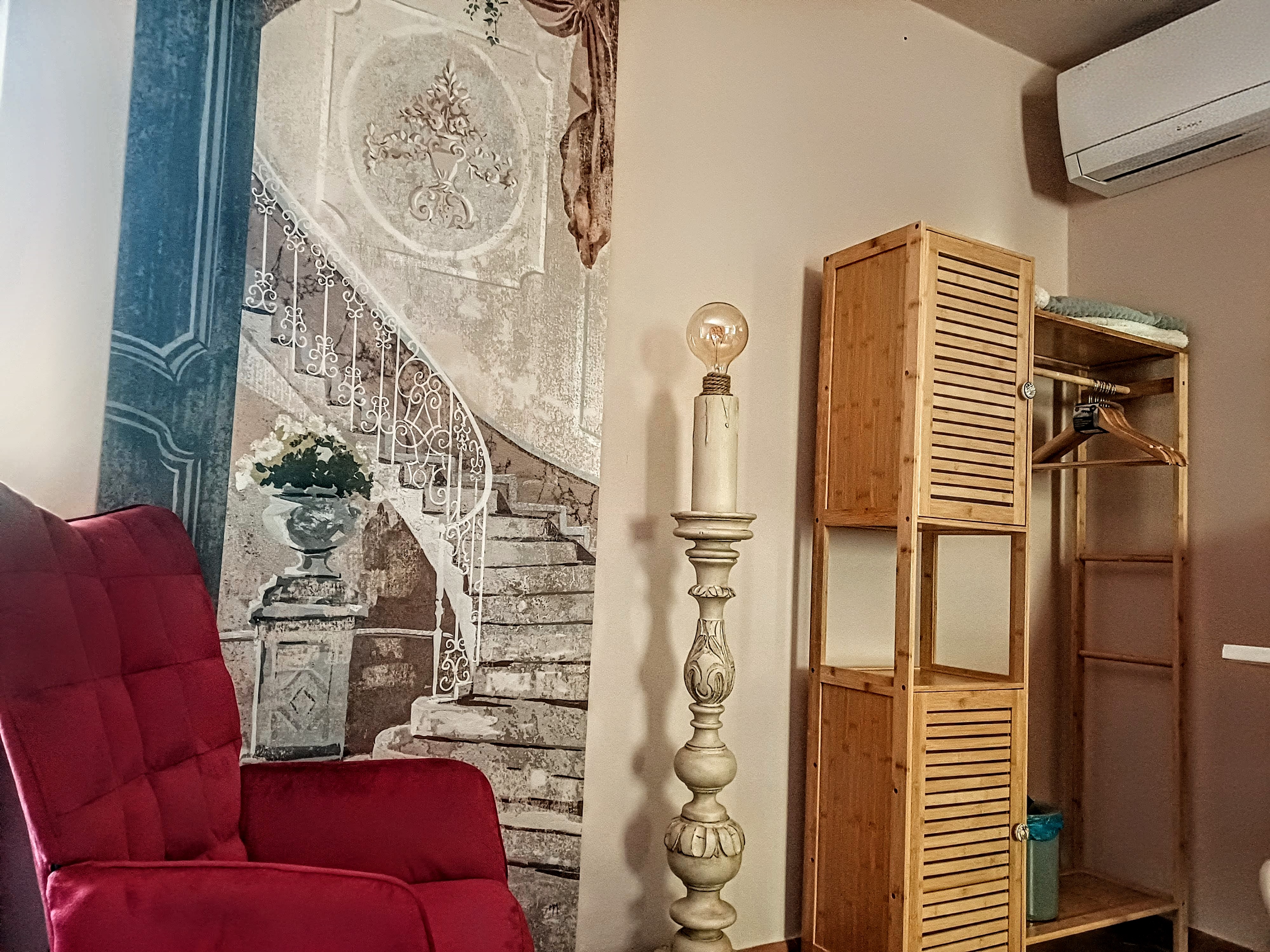 Comfortable armchair, wardrobe, and seating area in La Camelia Room at Genevieve Grove