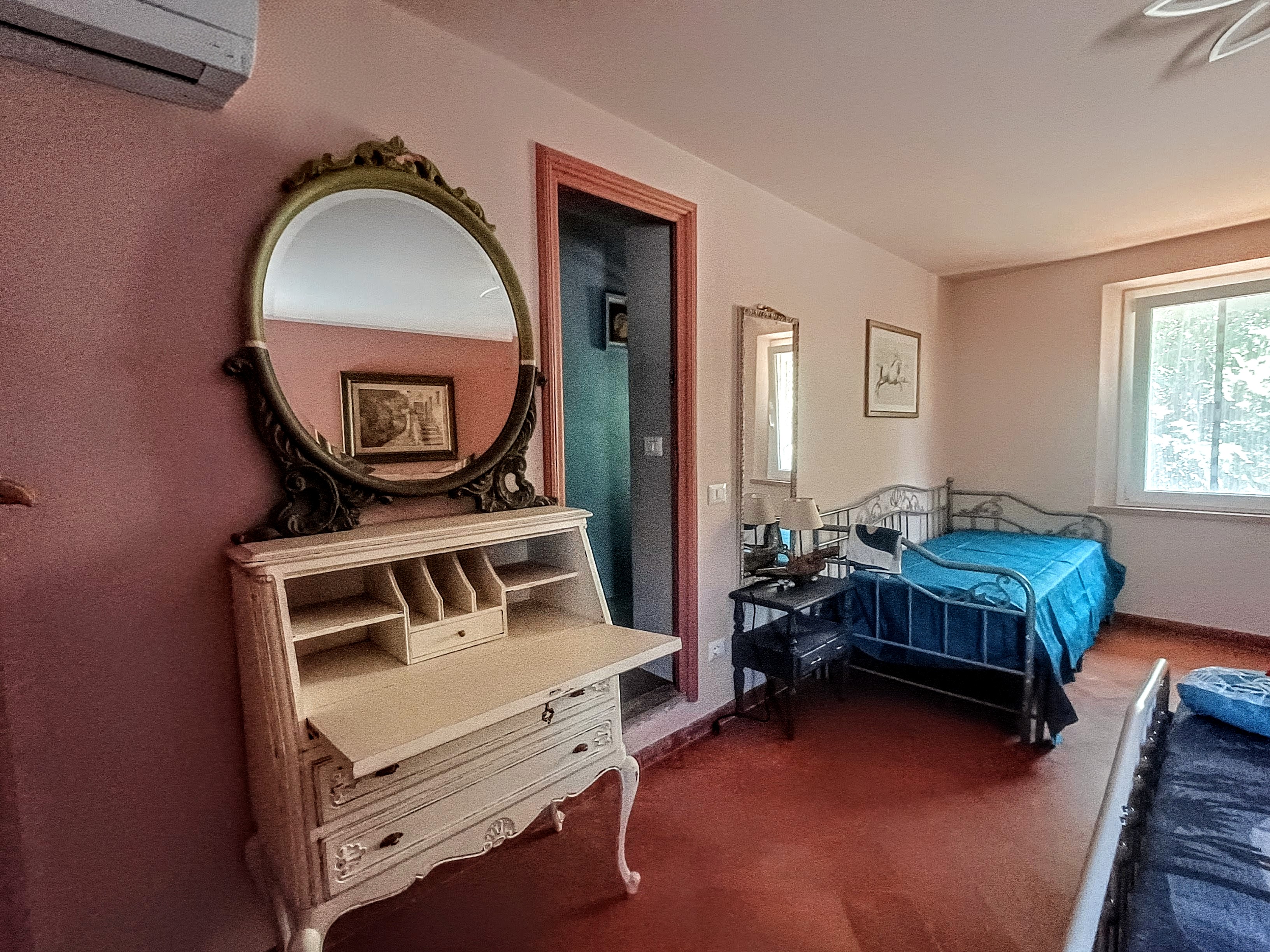 Vintage writing desk with decorative mirror in La Camelia Room at Genevieve Grove, Tuscany
